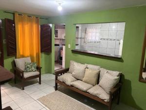 a green room with a couch and a mirror at Jully''s house in Arraial do Cabo +6 photos