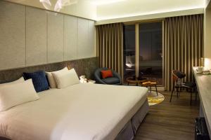 een hotelkamer met een groot bed en stoelen bij Metro Hotel in Douliu