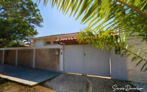 a house with a fence and a garage at Senses Dimension - Ipioca Beach Suites in Maceió