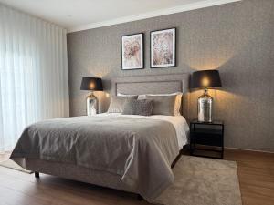 a bedroom with a bed with two lamps on it at Full private 180sqm Villa - Terrace Jacuzzi - 200m Beach & Sea View in Albufeira +24 photos