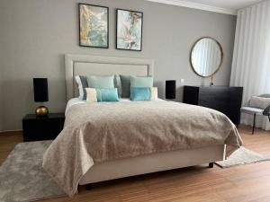 a bedroom with a large bed and a mirror at Full private 180sqm Villa - Terrace Jacuzzi - 200m Beach & Sea View in Albufeira