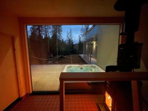Blick auf einen Whirlpool durch ein Fenster in der Unterkunft Fokus in Syöte