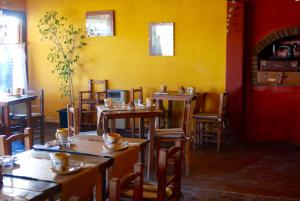 a restaurant with tables and chairs and a yellow wall at La Aldea in San Rafael
