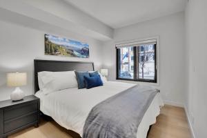 een witte slaapkamer met een bed en een raam bij 3 Bedroom with Heated Outdoor Pool and Hottub! in Canmore +54 foto's