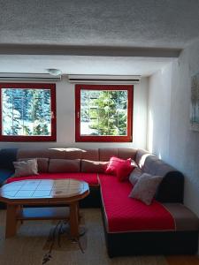 a living room with a couch with a table and two windows at Vikendica za odmor in Vlasic