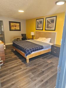 a bedroom with a bed in a room with yellow walls at ScottishINN Galloway in Galloway +1 photo