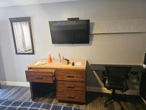 an office with a desk and a television on the wall at ScottishINN Galloway in Galloway