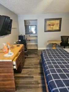 a room with a bed and a desk and a tv at ScottishINN Galloway in Galloway