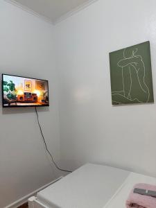a flat screen tv hanging on a white wall at Haraya Beach House in Roxas City