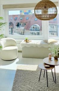 a living room with a white couch and a large window at BEACH apartment met directe toegang tot het STRAND ! in Knokke-Heist +33 photos