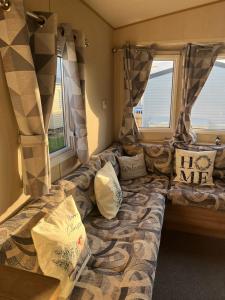 een bank in een kamer met 2 ramen bij Caravan at the seaside in Great Yarmouth +44 foto's