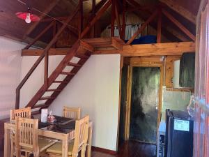 a dining room with a wooden table and a staircase at Cabaña, Sol y Paz in Lima