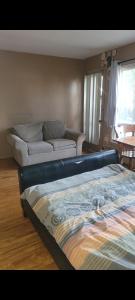 a living room with a bed and a couch at Very large room in Montreal