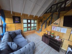 vista sul soffitto di un soggiorno con divano e scale di Cabaña el bosque de la bruja ad Ancud