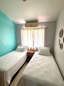 due letti in una piccola stanza con una finestra di Happy Oasis Second Floor Condo with Terrace a Coco Altre 24 foto