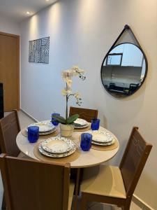 a dining room table with chairs and a mirror at Park Cowboy - Valentina in João Pessoa