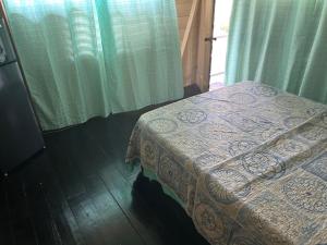 a bedroom with a bed and a window with a curtain at 3Dives Cliffside Rooms in Westlands