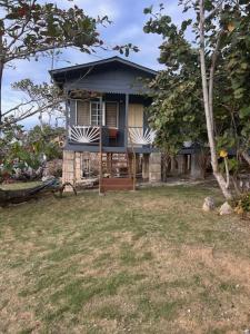a small house with a porch on a yard at 3Dives Cliffside Rooms in Westlands +7 photos