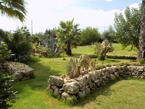 eine steinerne Mauer mit Pflanzen im Hof in der Unterkunft B&B Asparano in Ognina