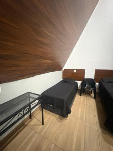 a room with two beds and a glass table at In concept chalé completo in Duque de Caxias