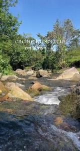 a stream of water with rocks and trees at In concept chalé completo in Duque de Caxias