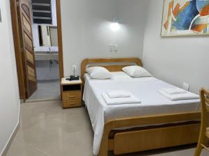 a small bedroom with a bed and a bathroom at Missouri Hotel in São Paulo