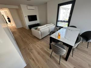 a living room with a table and chairs and a couch at L'Écrin Ludovicien - Chambres design & Spa in Saint-Louis