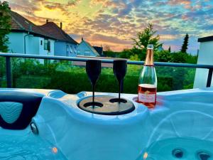 a bottle of wine and two glasses on a table at L'Écrin Ludovicien - Chambres design & Spa in Saint-Louis