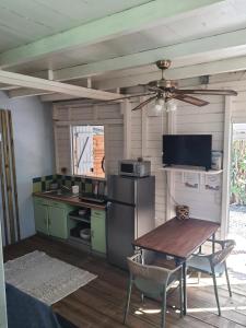 een keuken met een tafel en een plafondventilator bij Appartement cosy au Carbet avec balcon et vue sur mer - 70 m² in Le Carbet