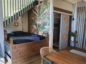 een bed in een kamer met een trap en een tafel bij Appartement cosy au Carbet avec balcon et vue sur mer - 70 m² in Le Carbet