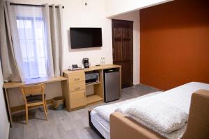 een hotelkamer met een bed en een bureau met een televisie bij Privada Guadalupe in Monterrey