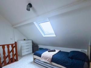 een kleine slaapkamer met een bed en een raam bij L'échappée belle pour 5 in Saint-Quentin