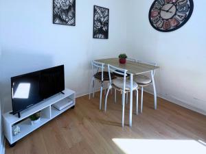 een woonkamer met een tafel met stoelen en een klok bij L'échappée belle pour 5 in Saint-Quentin