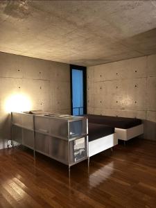 a large room with a bed and a window at One Floor Designed by Architect Tadao Ando in Ikuma