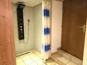 een douche in een badkamer met een tegelvloer bij Schloßblick in Ramingstein