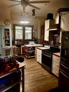 a kitchen with wooden floors and a stove top oven at Hale Naalehu LLC Bed and Breakfast in Naalehu