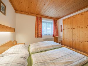 een slaapkamer met twee bedden en een raam bij Kitzsteinhorn in Kaprun