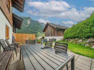 een houten terras met 2 stoelen en een gebouw bij Kitzsteinhorn in Kaprun