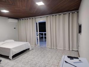 a bedroom with a bed and a television in it at Pousada do Centro in São Gabriel