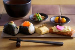 a group of sushi dishes on a table with chopsticks at 宿 ロイノハコ in Gotsu
