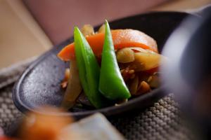 een bord met eten en groenten op tafel bij 宿 ロイノハコ in Gotsu