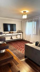 a living room with a couch and a flat screen tv at Teresopolis casa ampla em clube com piscina in Teresópolis +59 photos