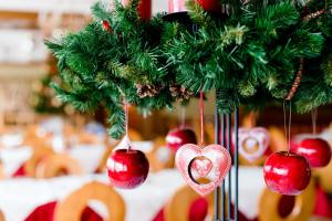 a christmas tree with red balls and a heart ornament at Landhotel Häuserl im Wald in Gröbming +104 photos