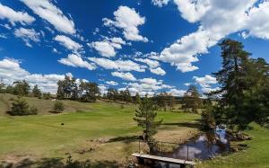 una vista de un campo de golf con un estanque en SunStone Apartment, en Zlatibor