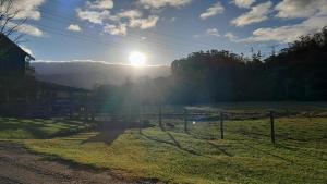 a field with the sun setting in the sky at Casa Manarin in Água Boa