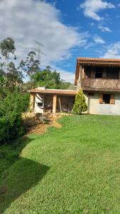 a house with a grass yard in front of it at Casa Manarin in Água Boa