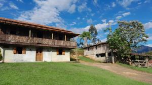 a house with a grass yard next to a building at Casa Manarin in Água Boa