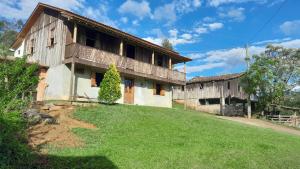 a house with a green yard in front of it at Casa Manarin in Água Boa