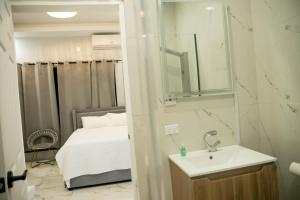 a small bathroom with a sink and a bed at Hillside Haven in Kingston