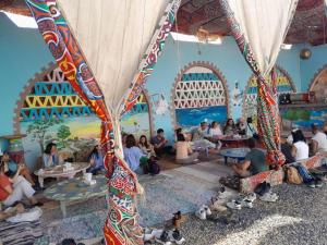 a group of people sitting in a room with a mural at Hllol Hotel Abu Simbel in Abu Simbel